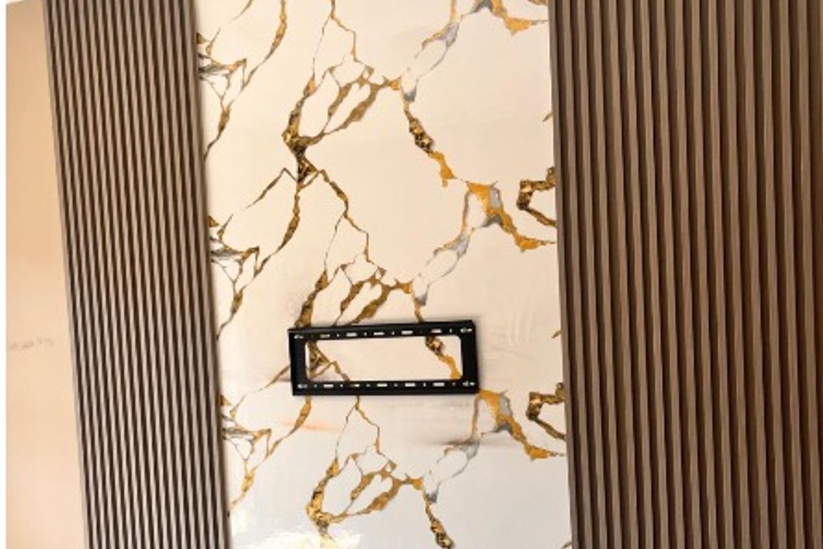 A modern living room feature wall showcasing marble-effect tiling flanked by decorative vertical timber slat paneling and integrated electrical points.
