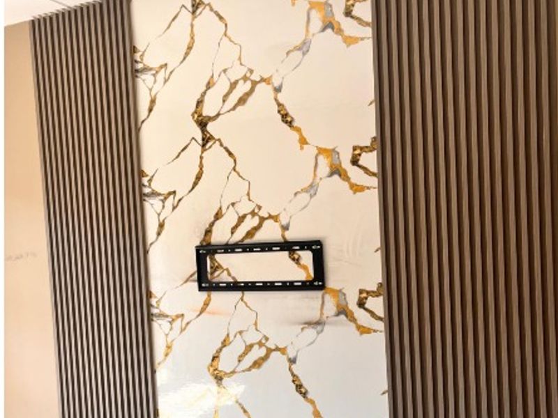 A modern living room feature wall showcasing marble-effect tiling flanked by decorative vertical timber slat paneling and integrated electrical points.