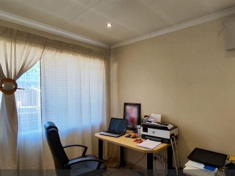 A functional home office space featuring recessed downlighting and a large window, providing a bright and practical area for work or study.