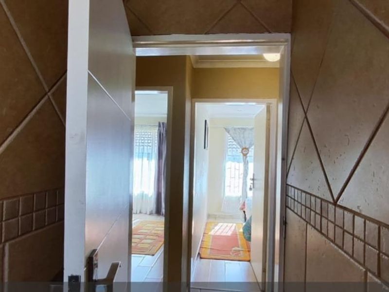A hallway featuring tiled walls and multiple doorways leading into adjacent rooms.
