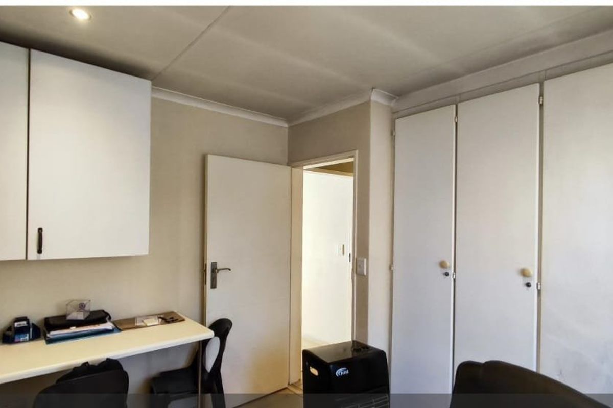 Bedroom featuring extensive built-in storage cupboards and a fitted desk area with recessed ceiling lighting.