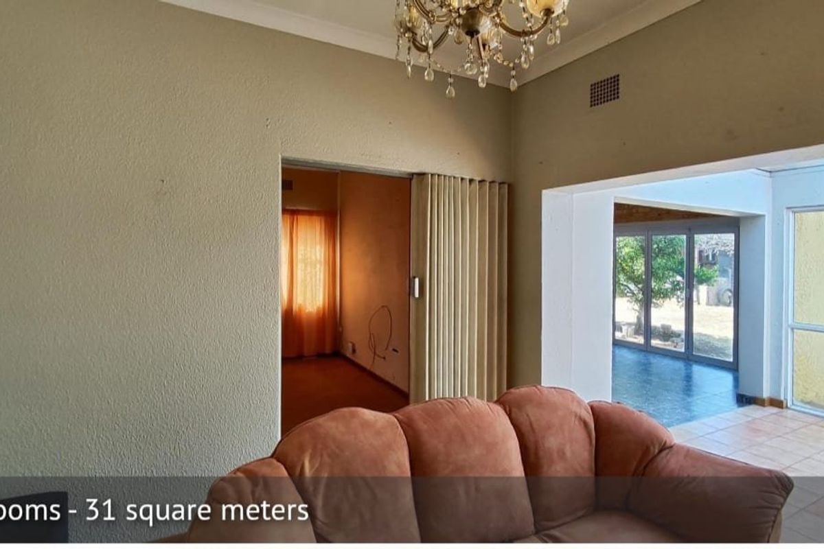 Living area featuring a folding room divider, tiled flooring, and access to an enclosed patio through sliding glass doors.