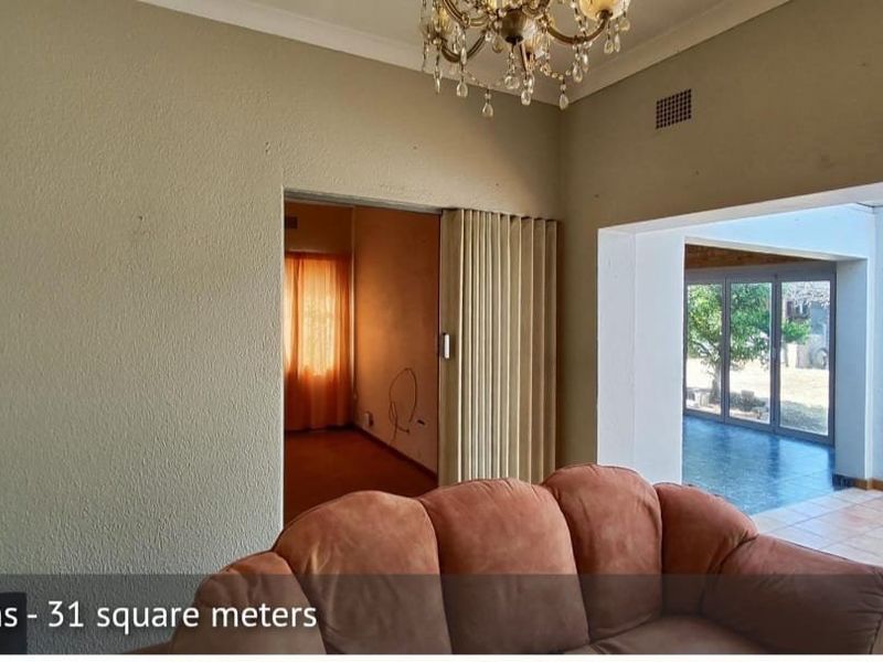 Living area featuring a folding room divider, tiled flooring, and access to an enclosed patio through sliding glass doors.