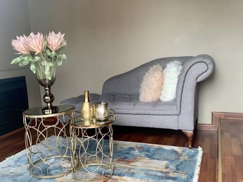 A cozy living room area featuring warm-toned laminate flooring and a built-in fireplace, creating a comfortable and inviting atmosphere.