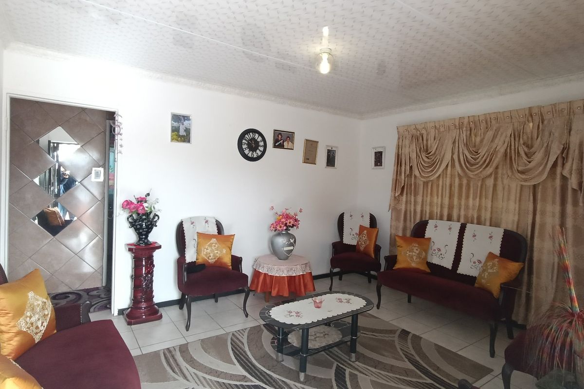 A living room featuring tiled flooring and a textured ceiling, providing a functional space for relaxation.