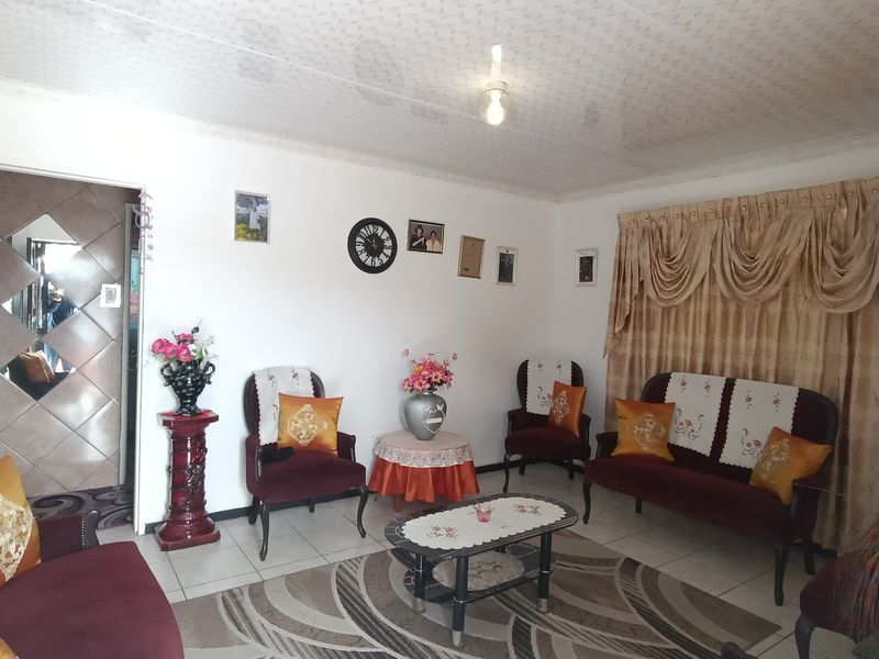 A living room featuring tiled flooring and a textured ceiling, providing a functional space for relaxation.