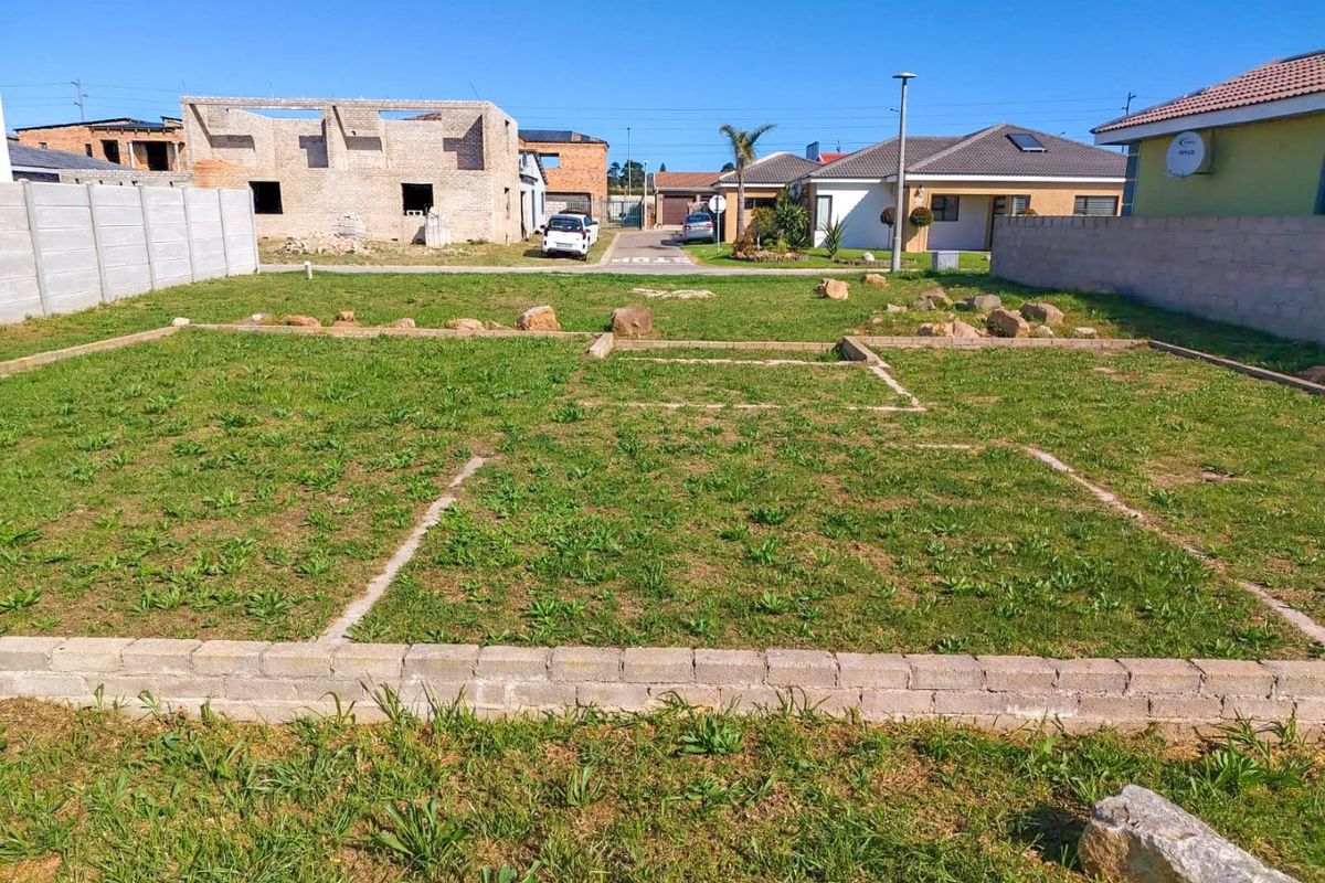A vacant residential plot featuring a concrete foundation slab and surrounding precast boundary walls in a developing neighborhood.