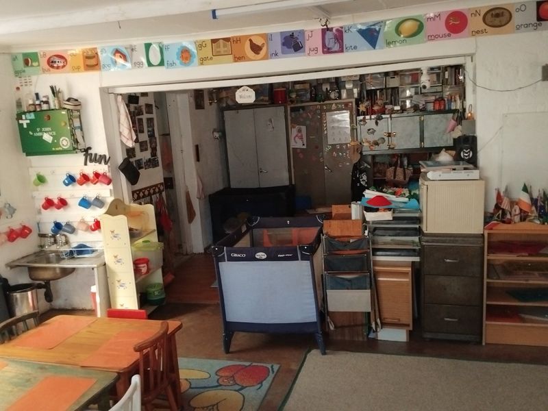 A utility or multi-purpose space featuring built-in cabinetry and a small sink, currently utilized for storage and activity purposes.