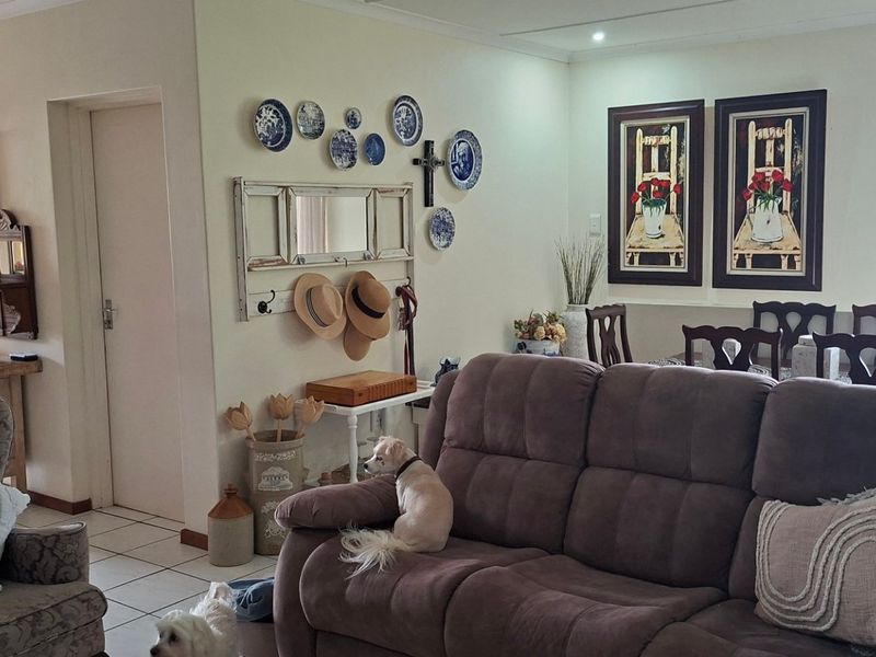 An open-plan living and dining area featuring tiled flooring and neutral wall finishes, providing a functional and connected space for daily living.