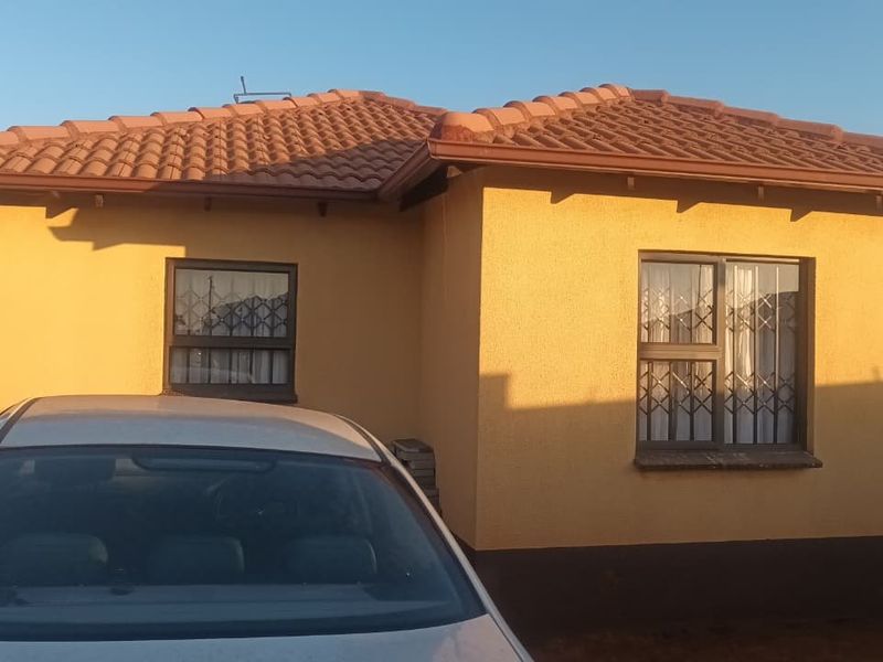 Front elevation of a single-story house featuring a tiled roof and security bars on the windows.