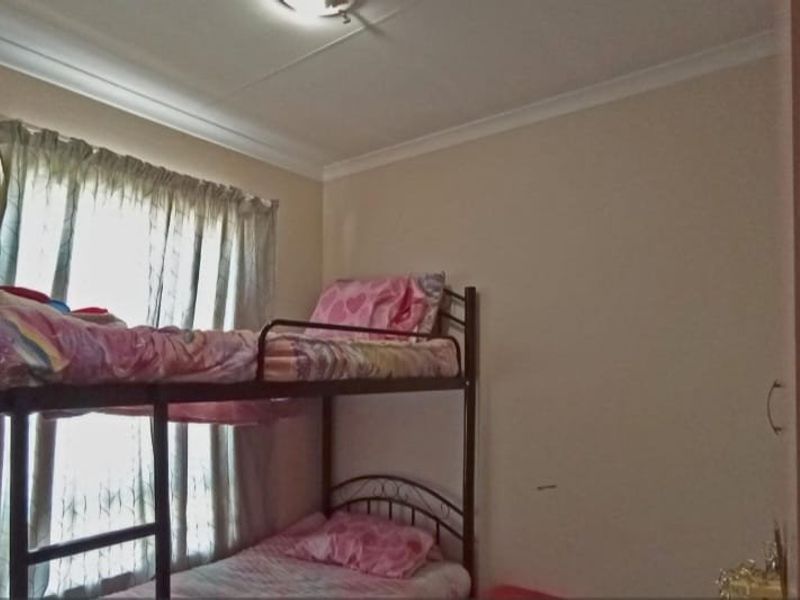 A standard bedroom featuring a built-in cupboard and coving detail, providing a functional space for residents.
