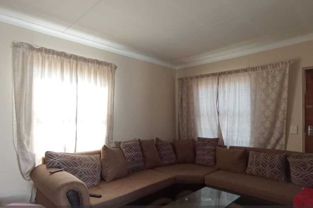 A living room featuring neutral wall finishes, cove cornicing, and natural light through multiple windows.