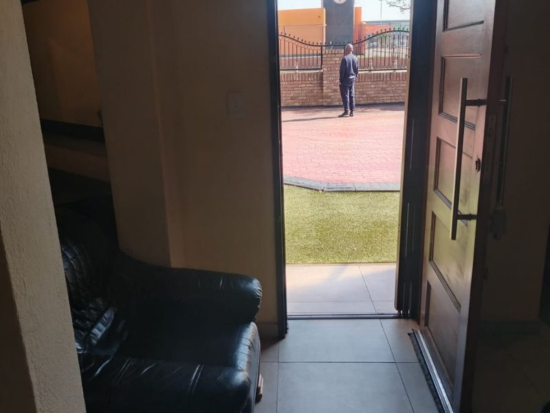 An entry area featuring tiled flooring and a solid wood door opening to an exterior paved area.