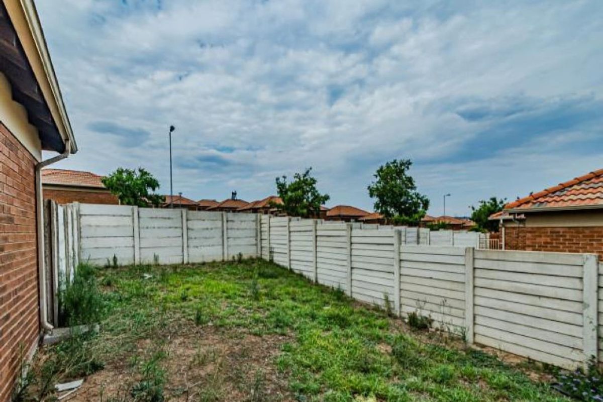A private rear garden area featuring a precast concrete boundary wall and brick exterior walling, offering potential for landscaping and outdoor improvement.