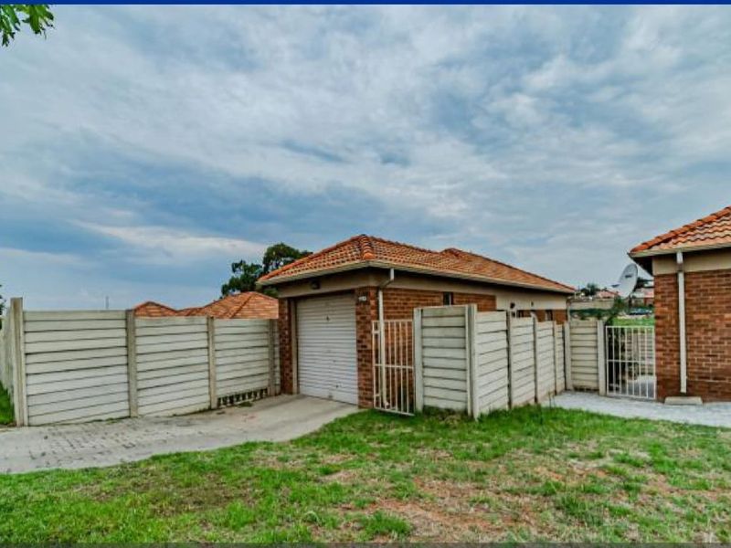 Exterior view of a brick house featuring a single garage, concrete driveway, and perimeter precast concrete walling.