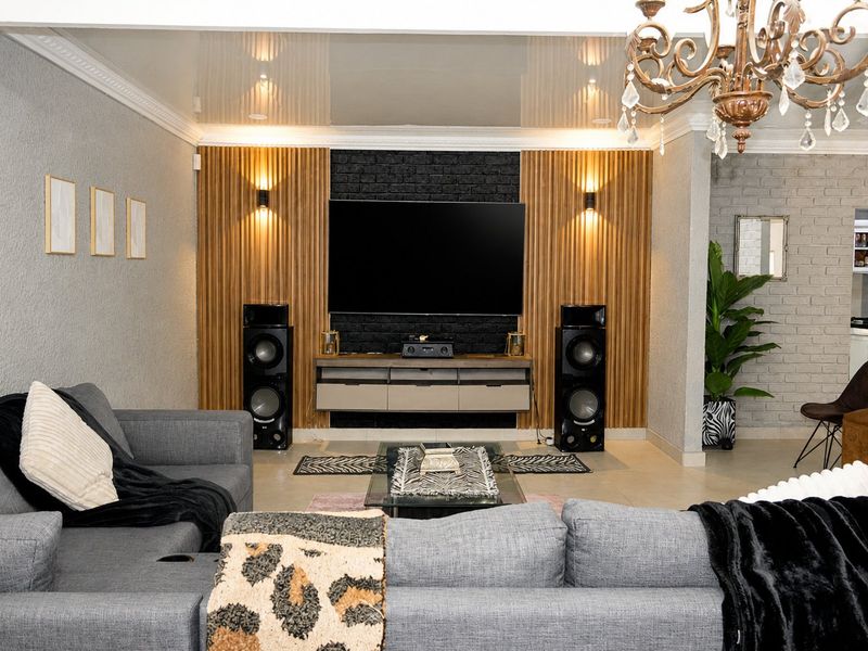 A modern living room featuring a striking timber slat and black brick feature wall, complemented by recessed lighting and elegant crown molding.