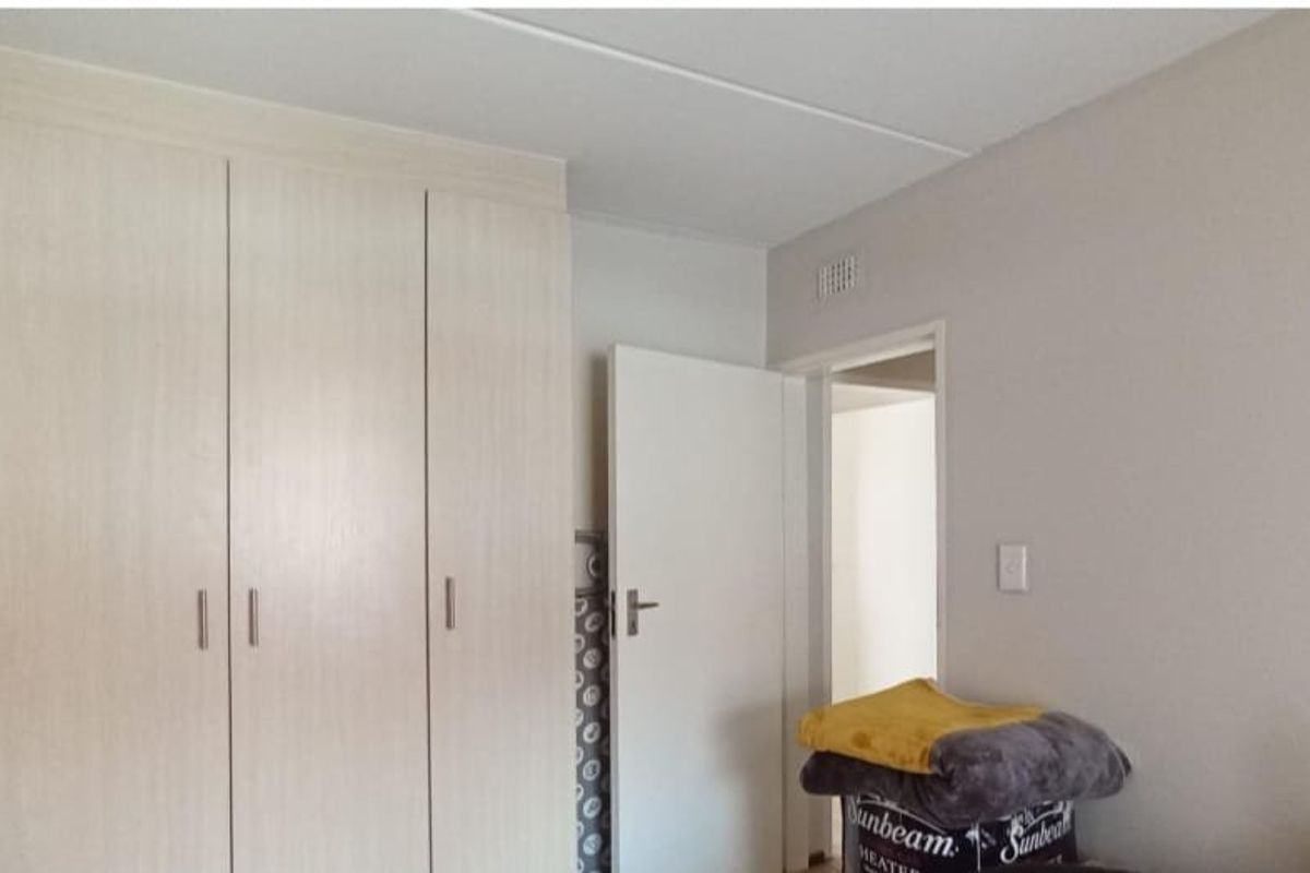 A bedroom featuring neutral walls and functional built-in cupboards, providing ample storage space within the apartment.
