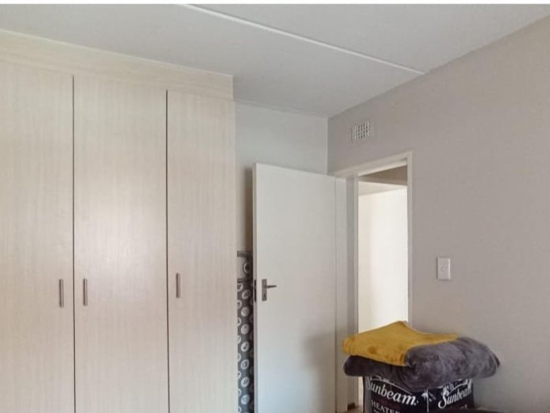 A bedroom featuring neutral walls and functional built-in cupboards, providing ample storage space within the apartment.