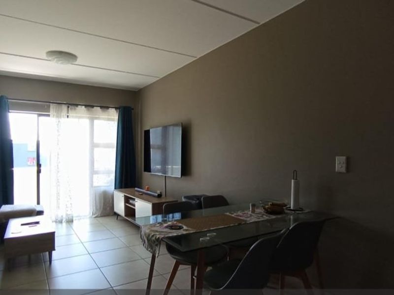 Open plan living and dining area featuring tiled flooring and a sliding glass door providing access to the exterior.