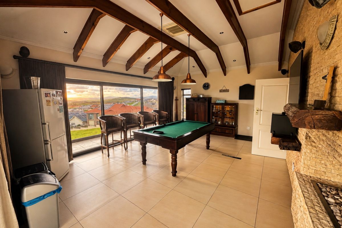 Spacious living area featuring exposed timber beams, tiled flooring, a stone feature wall, and large sliding doors offering expansive views.