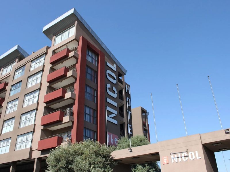 Exterior view of The Nicol apartment building featuring modern facade design, balconies, and prominent entrance signage.