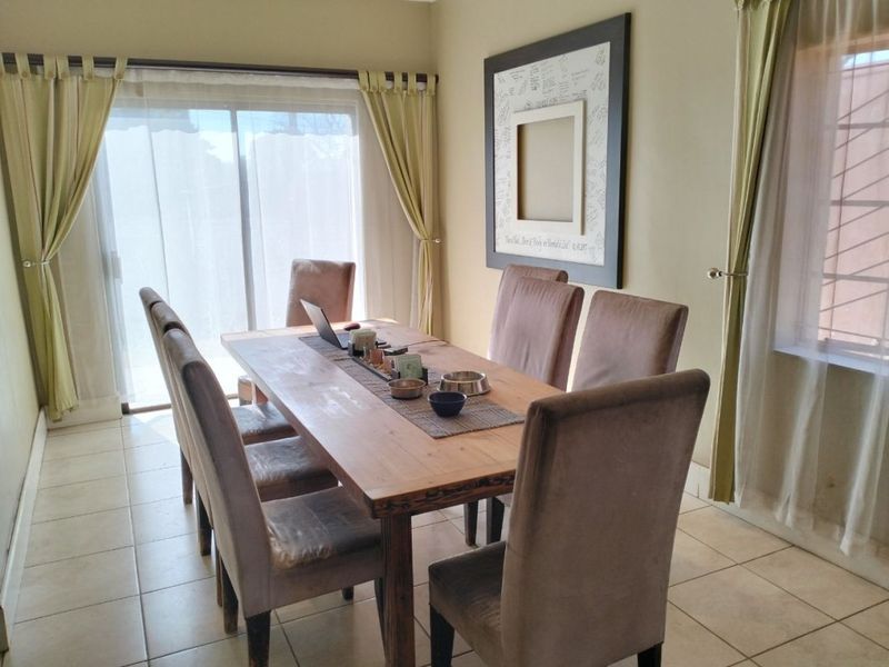 A dining room featuring ceramic floor tiles and a sliding glass door providing natural light.