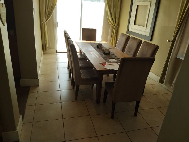 A dining room featuring tiled flooring and a sliding glass door providing natural light.