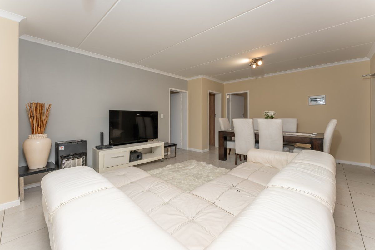 A spacious living and dining area featuring neutral wall tones, tiled flooring, and a functional open-plan layout suitable for comfortable family living.