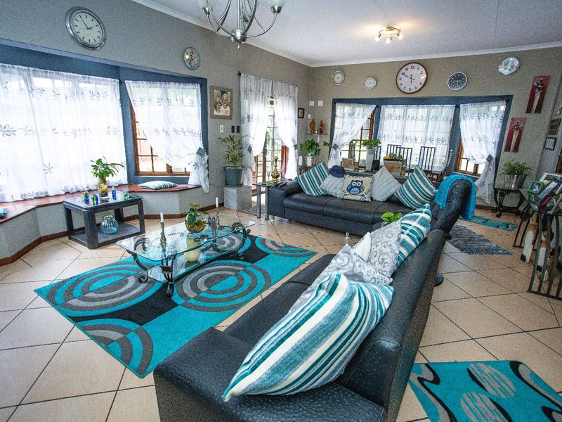 Spacious living room featuring tiled flooring, a large bay window with built-in seating, and ample natural light.