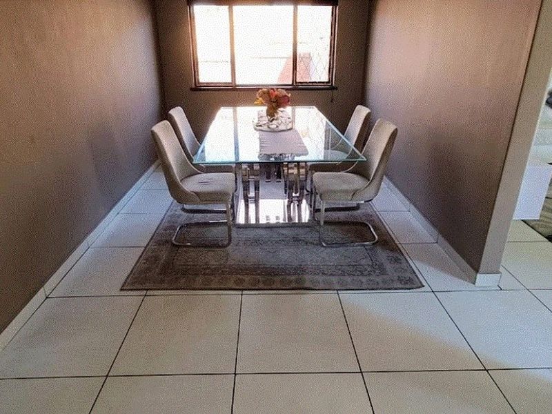 A dining room area featuring tiled flooring and a window, providing a functional space for meals.