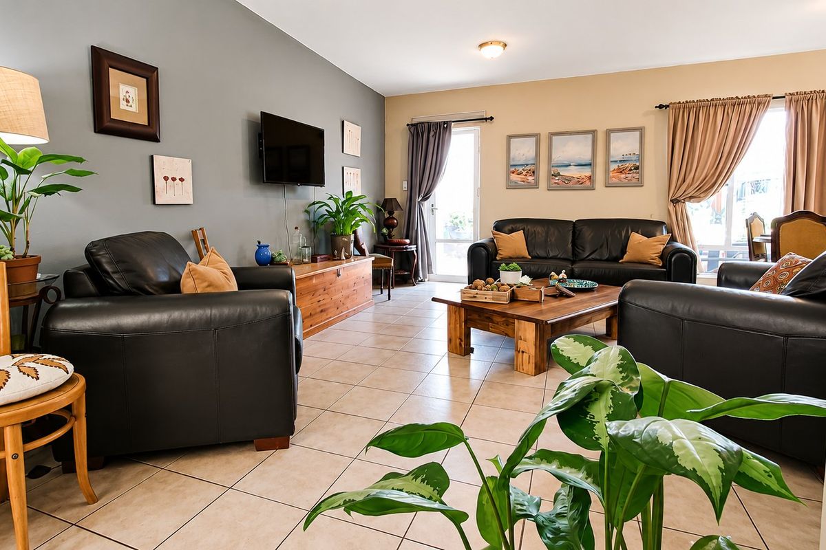 Spacious living room featuring neutral wall tones, tiled flooring, and direct access to the outdoor area through a sliding glass door.