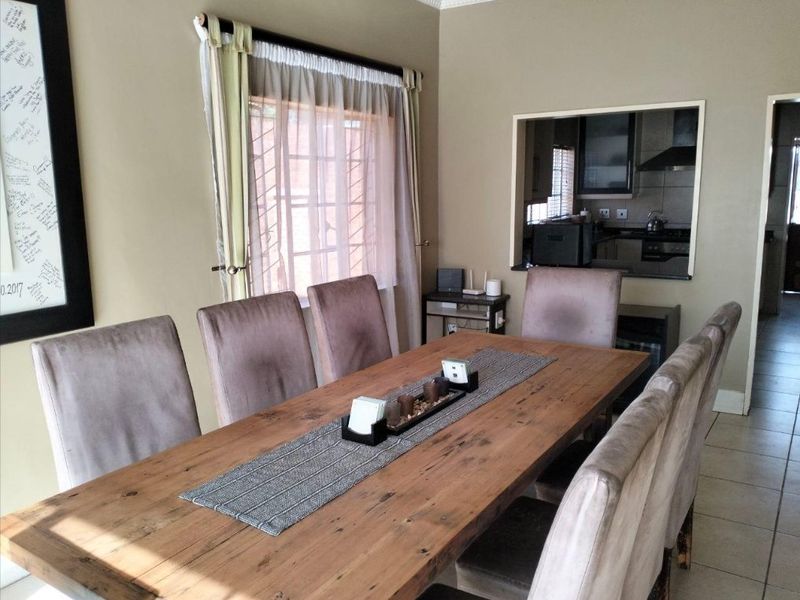Dining room featuring tiled flooring and a convenient serving hatch connecting to the kitchen area.