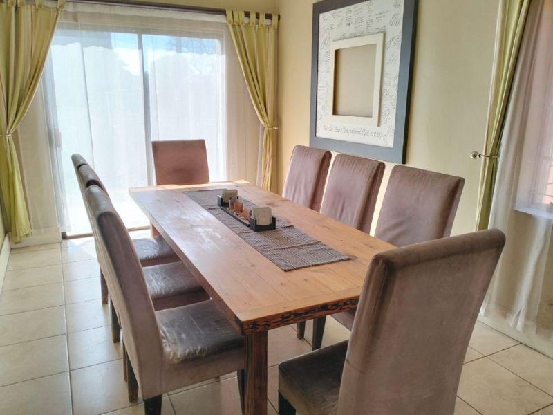 A dining room featuring ceramic floor tiles and a large sliding glass door providing natural light and access to the outdoor area.