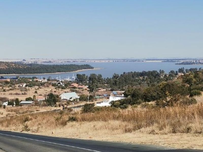 A scenic landscape view overlooking a large water body and surrounding residential area.