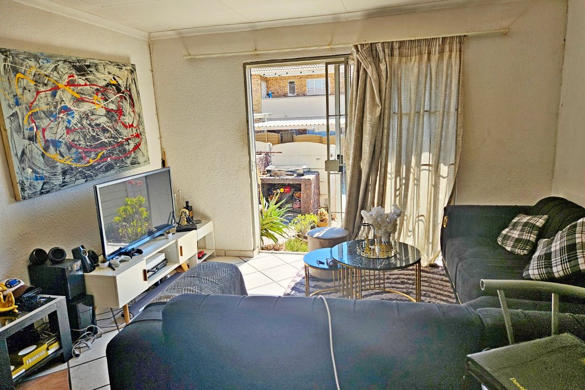 Living room featuring tiled flooring and a sliding glass door providing access to the outdoor area.