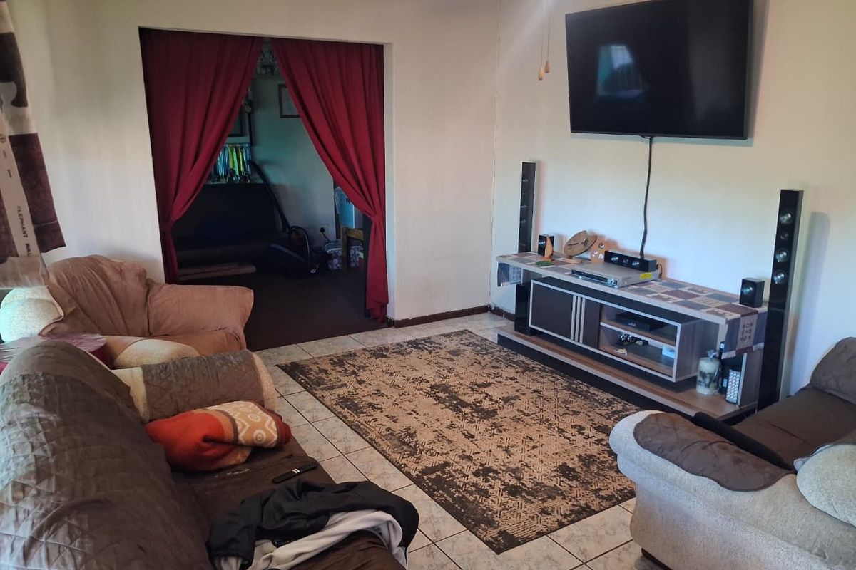 A living room featuring tiled flooring and a ceiling fan, providing a functional space for relaxation and entertainment.