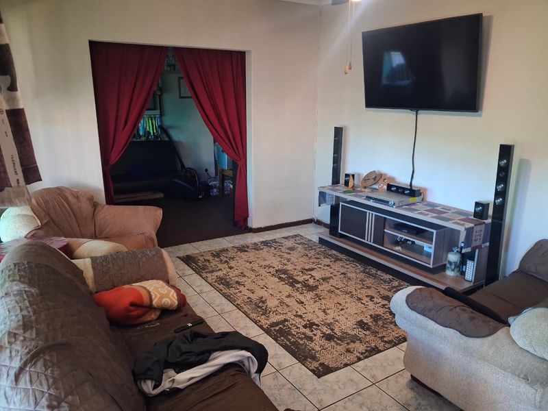 A living room featuring tiled flooring and a ceiling fan, providing a functional space for relaxation and entertainment.