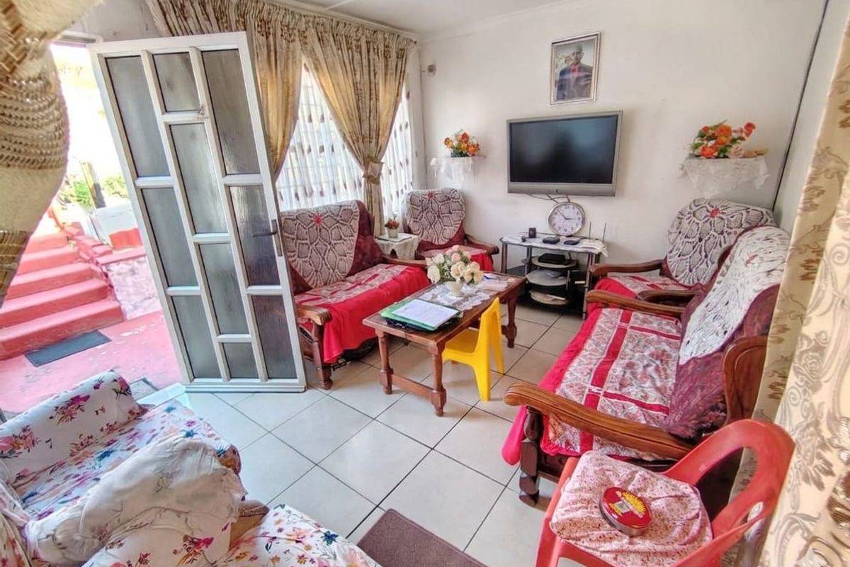 A functional living room featuring tiled flooring and direct access to an outdoor area through a sliding glass door.