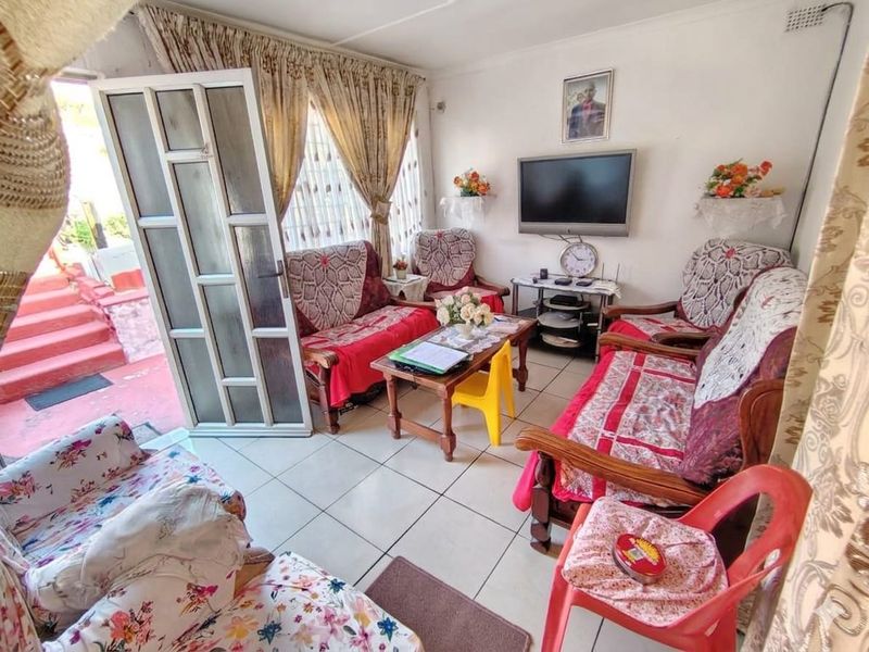 A functional living room featuring tiled flooring and direct access to an outdoor area through a sliding glass door.