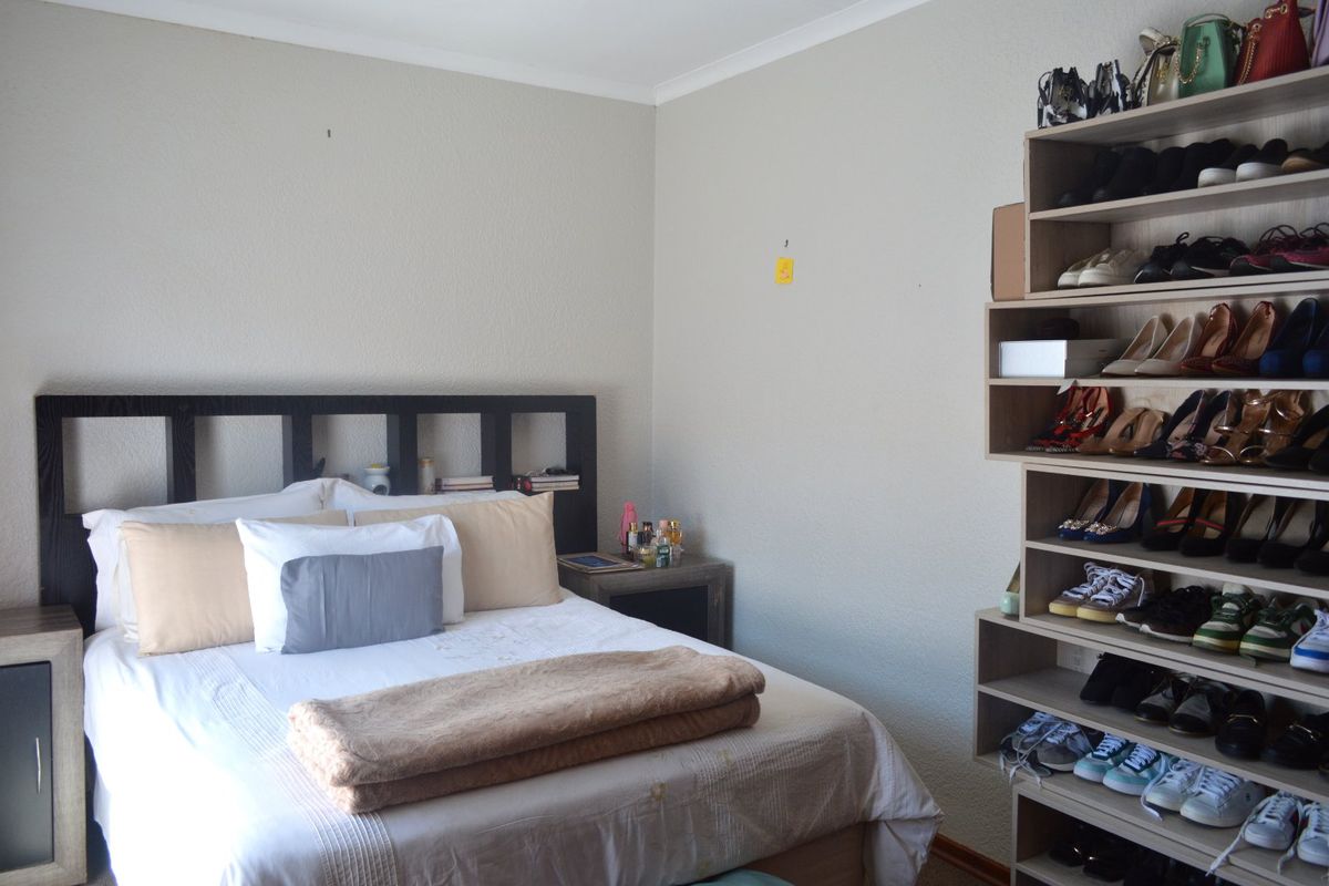 A bedroom featuring neutral walls and built-in shelving units, providing functional storage space.