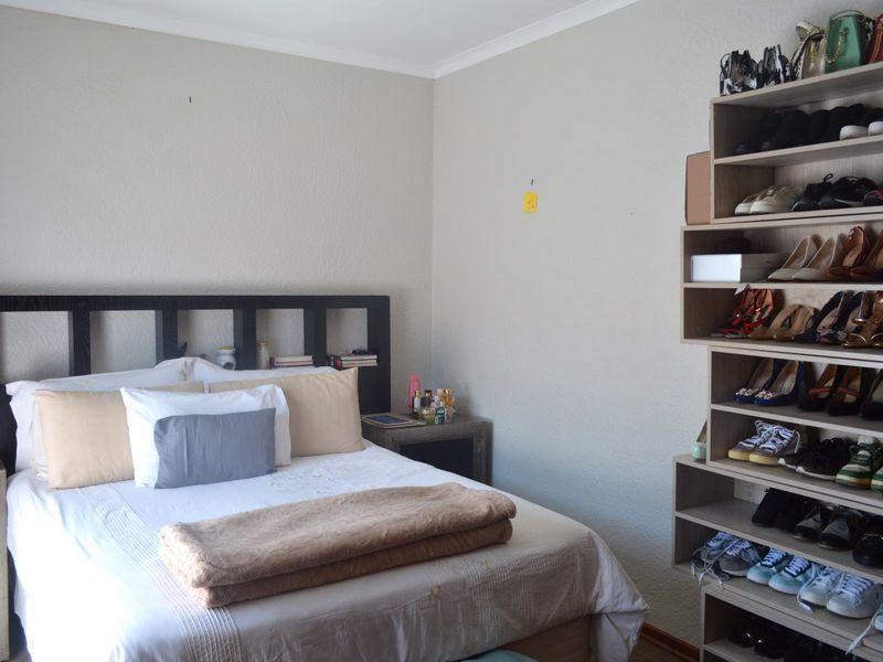 A bedroom featuring neutral walls and built-in shelving units, providing functional storage space.