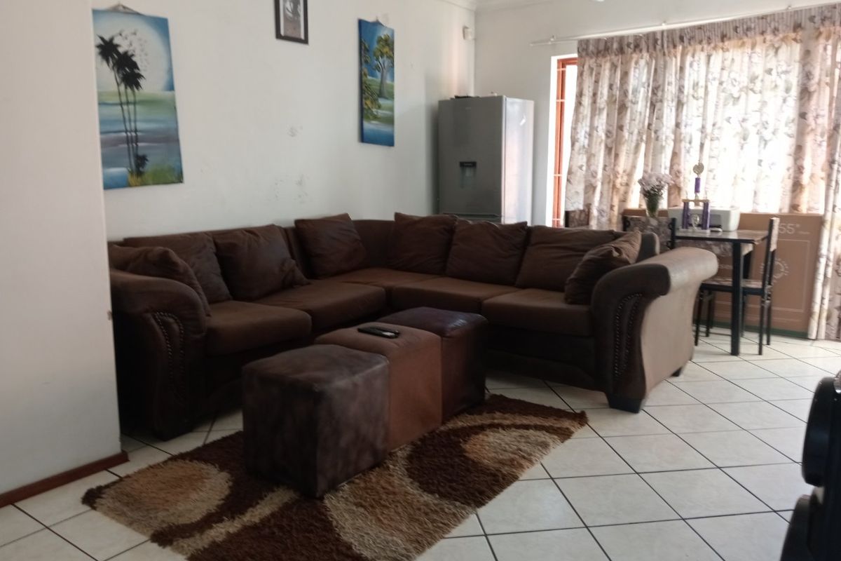 A living room area featuring tiled flooring and neutral wall finishes, providing a functional space for relaxation.
