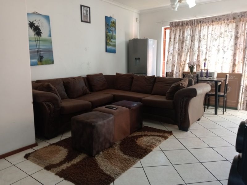A living room area featuring tiled flooring and neutral wall finishes, providing a functional space for relaxation.