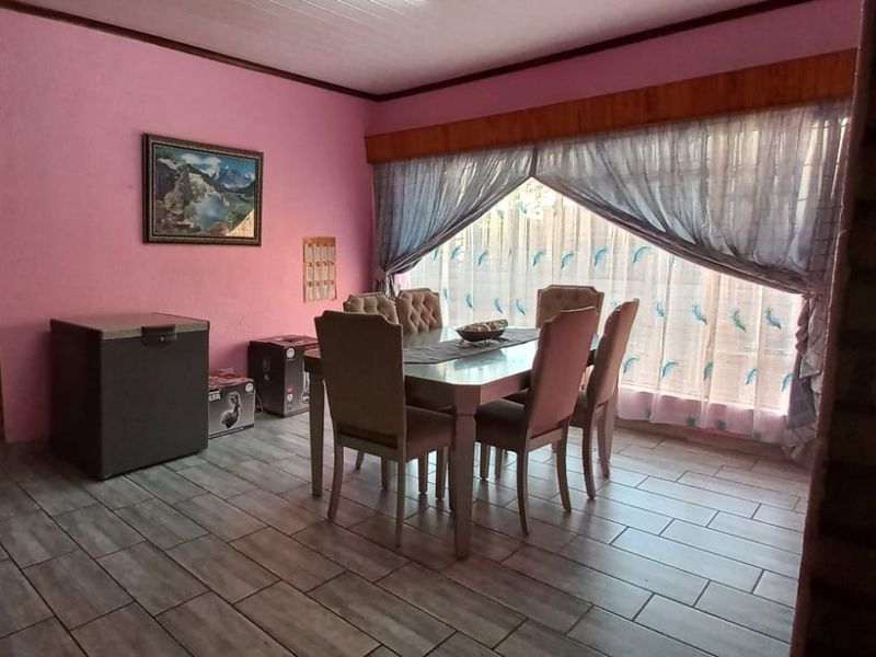 A dining room featuring tiled flooring and a timber window pelmet, providing a functional space for family meals.