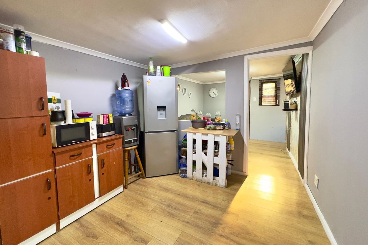 A functional kitchen area featuring laminate flooring and built-in cabinetry, providing a practical layout with direct access to the adjacent living space.