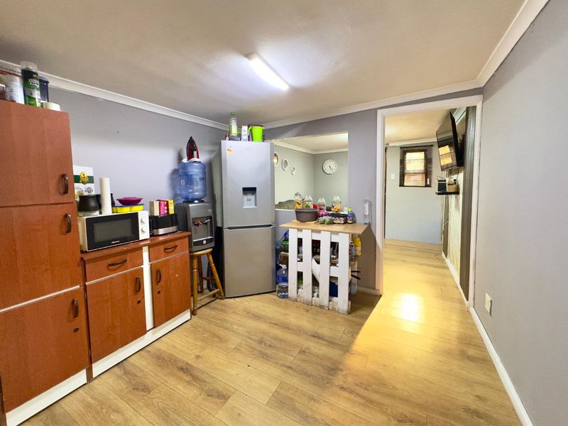 A functional kitchen area featuring laminate flooring and built-in cabinetry, providing a practical layout with direct access to the adjacent living space.