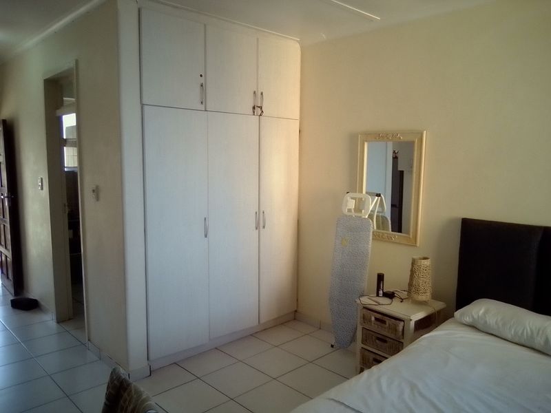 A bedroom featuring built-in cupboards and tiled flooring, providing functional storage space within the apartment.