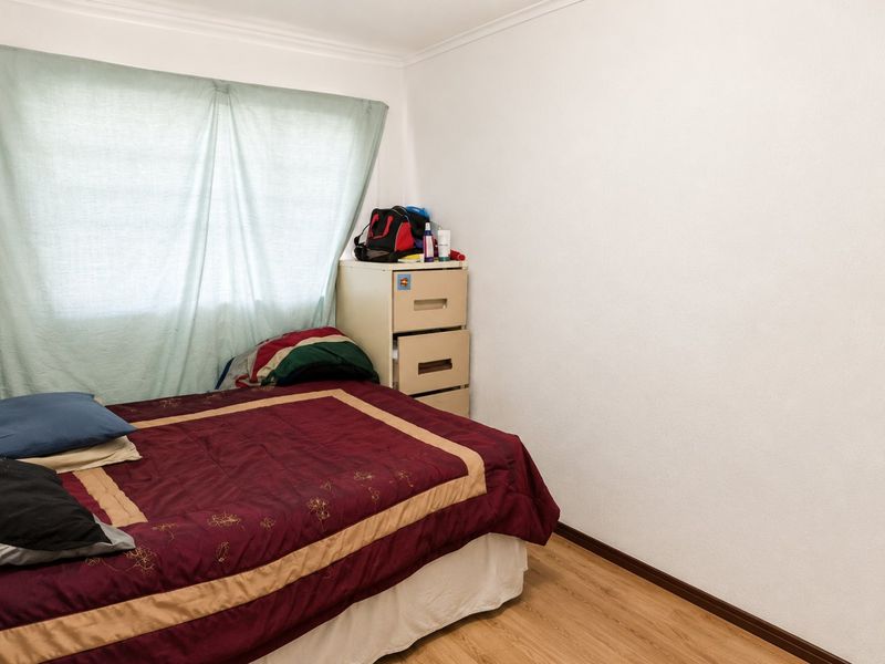 A standard bedroom featuring laminate flooring and neutral walls, providing a functional space ready for personalization.
