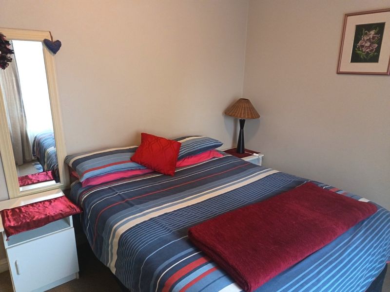 A standard bedroom featuring neutral wall finishes and carpeted flooring.