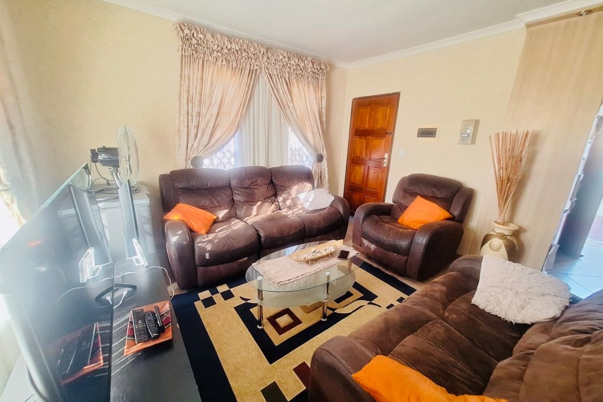 A comfortable living room featuring a coved ceiling and a solid timber door, providing a functional and traditional living space.